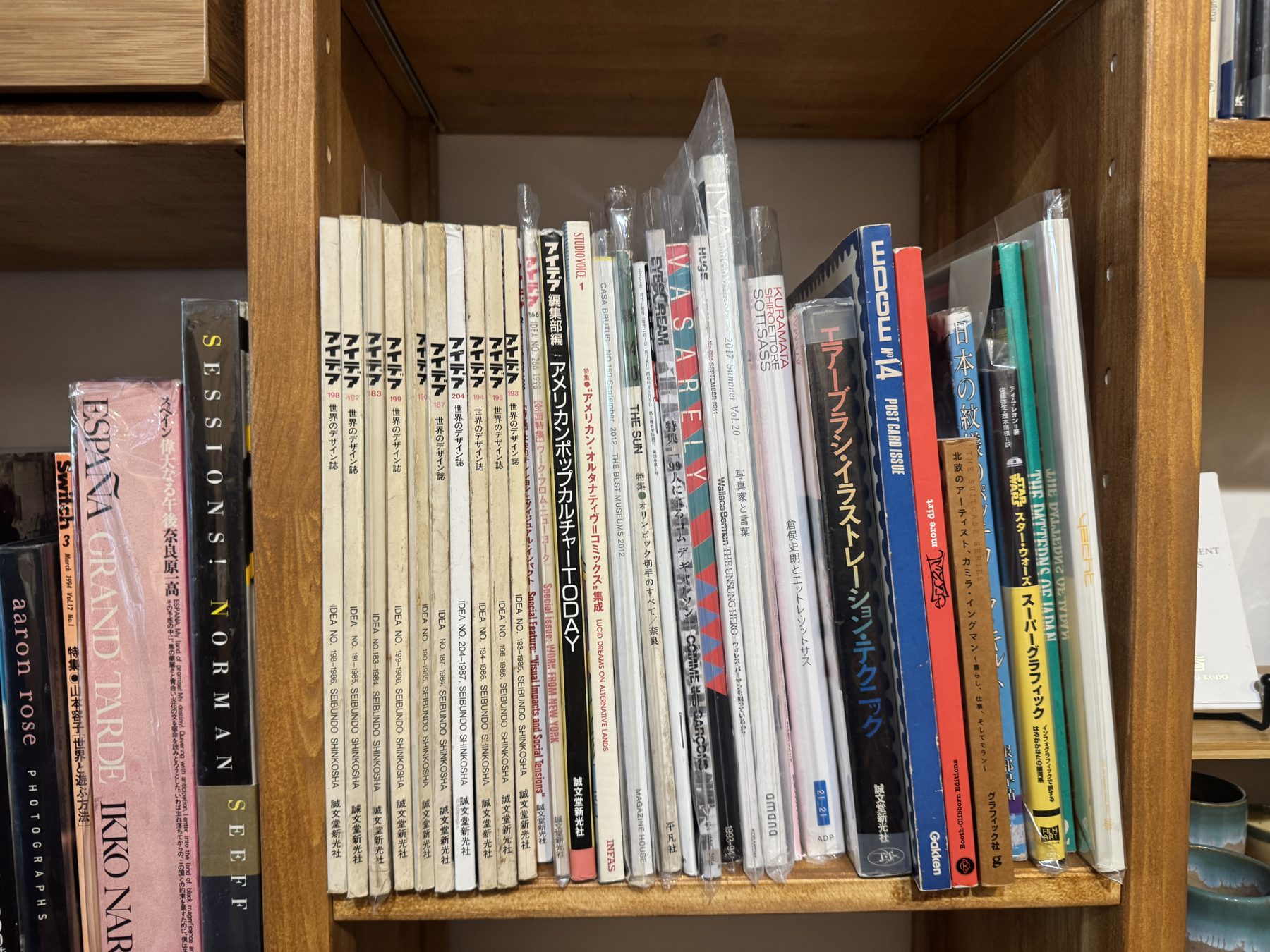 Japanese design magazines on a wooden shelf